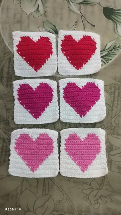 Handmade crochet heart coasters in red, magenta & pink